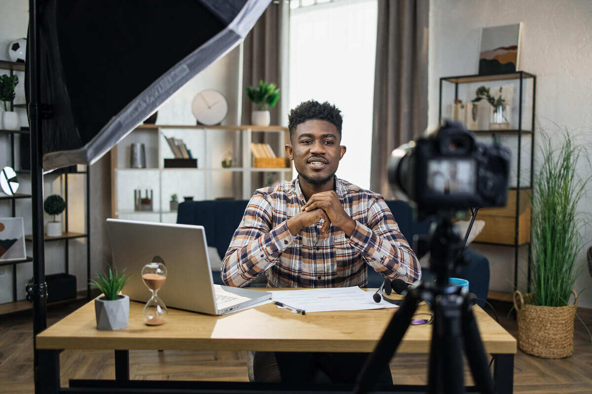 African man recording video on camera at home influencer marketing nyc