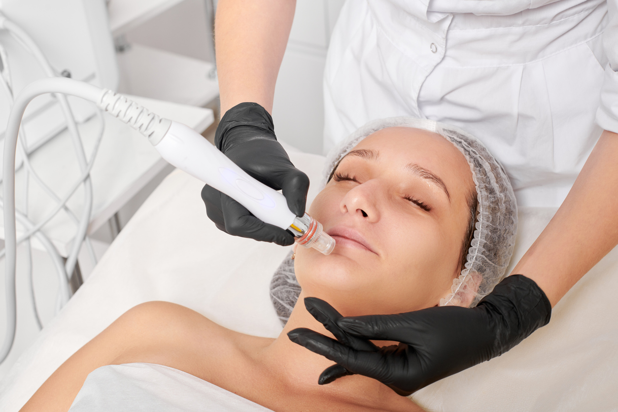 Cosmetologist makes aqua exfoliation for rejuvenation woman face skincare, procedure in beauty salon